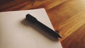 black pen and notebook on wooden table