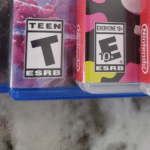 The ESRB logo on four different video game covers lined up on a kitchen counter.