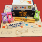 A pile of board games on a red background.